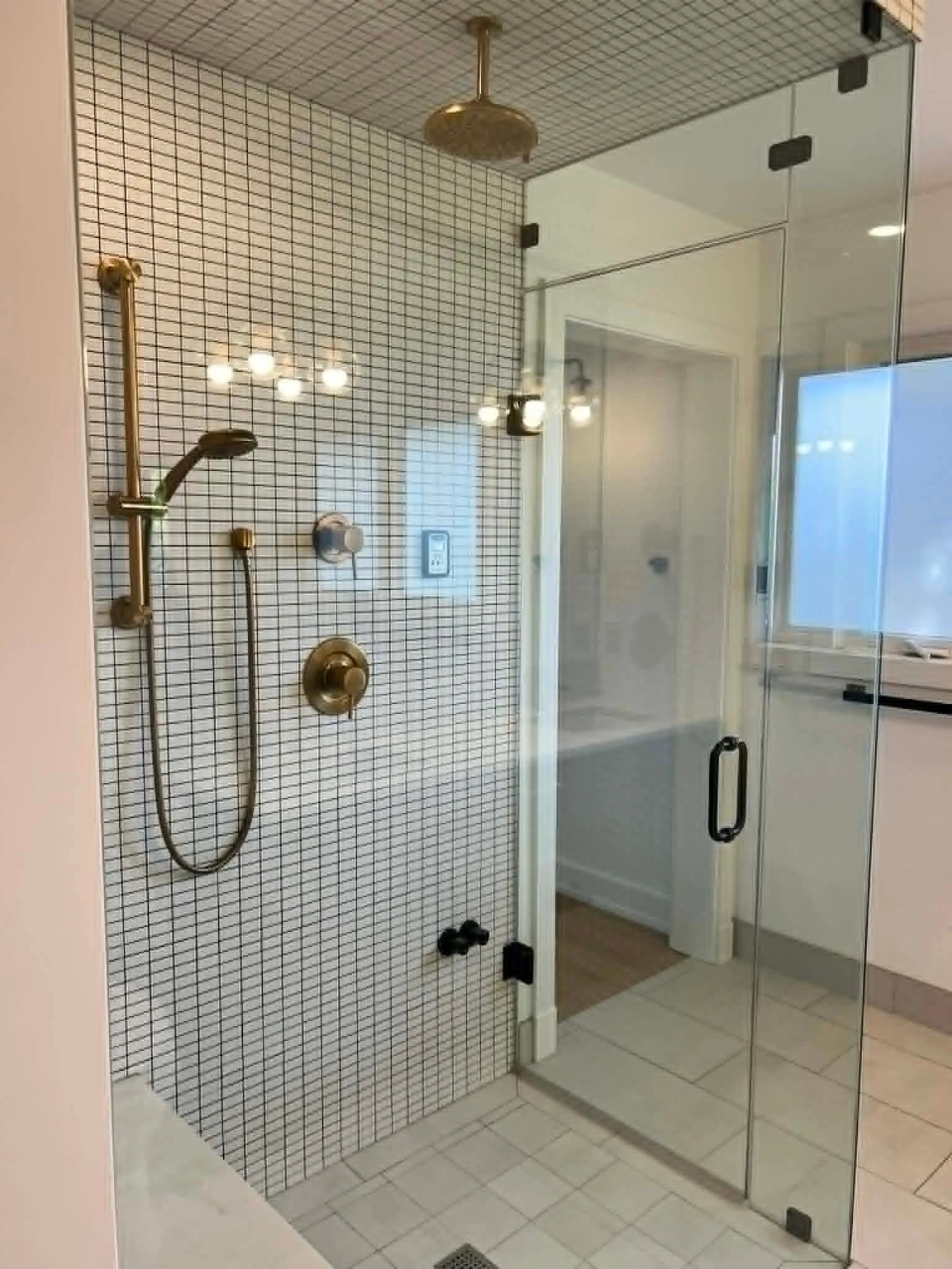 Clean glass shower and tiled bathroom